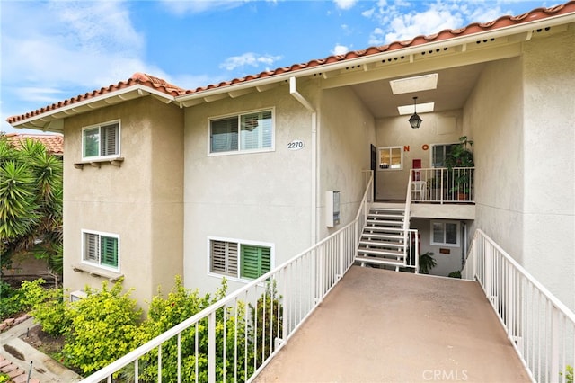 property entrance featuring stucco siding and a tile roof