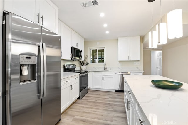 kitchen with appliances with stainless steel finishes, light wood finished floors, white cabinetry, visible vents, and recessed lighting