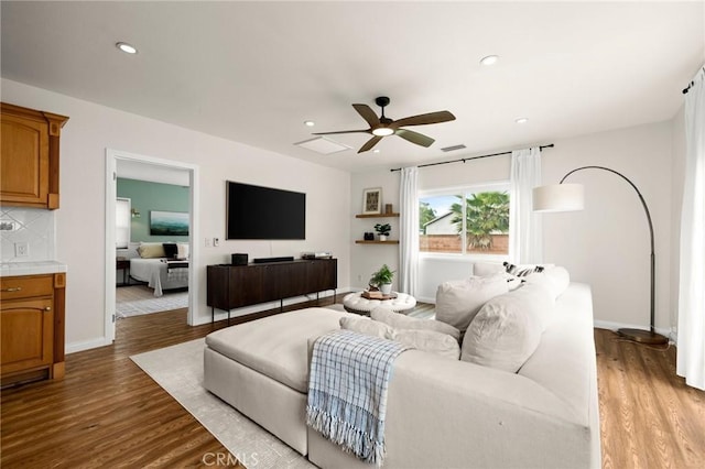 living room featuring recessed lighting, wood finished floors, visible vents, a ceiling fan, and baseboards
