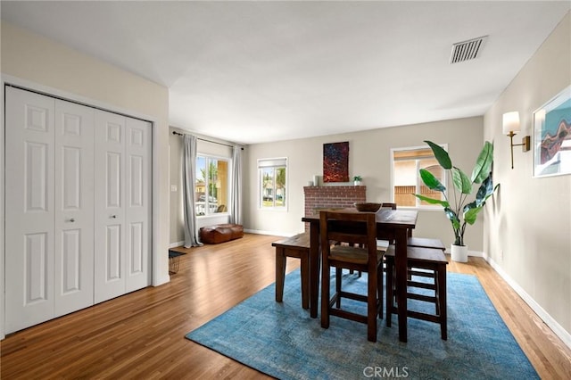 dining room with baseboards, visible vents, and wood finished floors