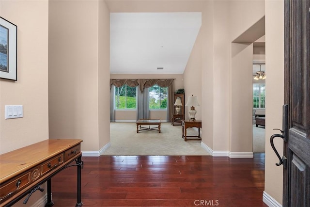 entrance foyer with baseboards, wood finished floors, and high vaulted ceiling