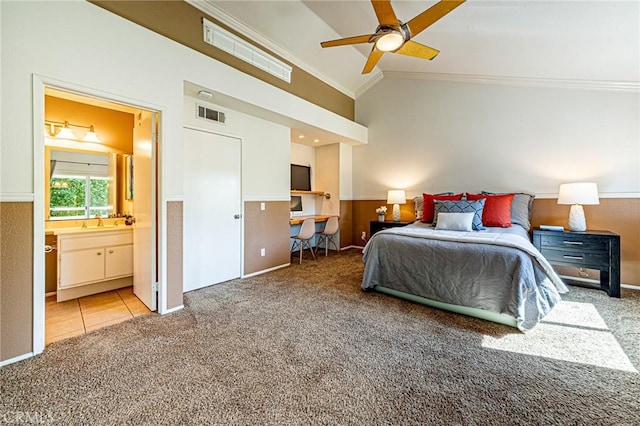 carpeted bedroom featuring visible vents, lofted ceiling, crown molding, and a sink