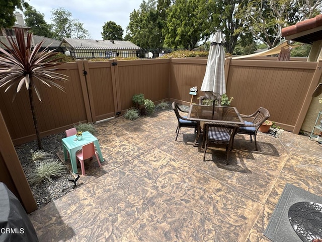 view of patio / terrace featuring a fenced backyard, a gate, and outdoor dining space