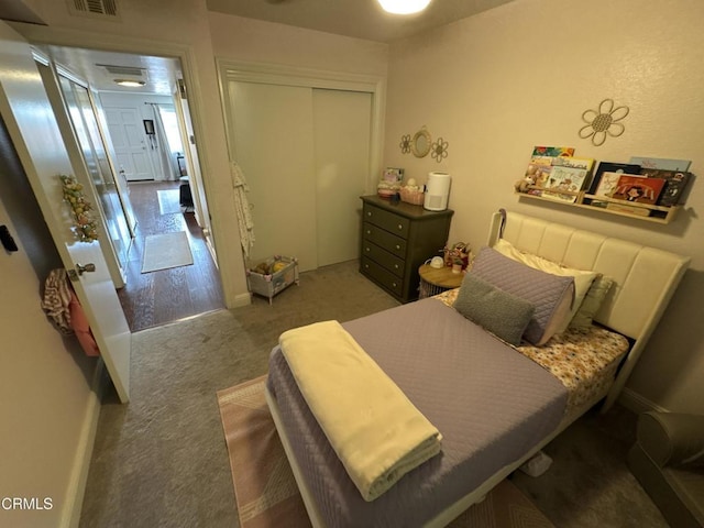 carpeted bedroom featuring visible vents, baseboards, and a closet