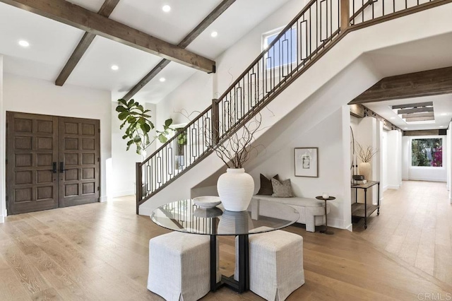 foyer featuring recessed lighting, wood finished floors, beamed ceiling, baseboards, and stairs