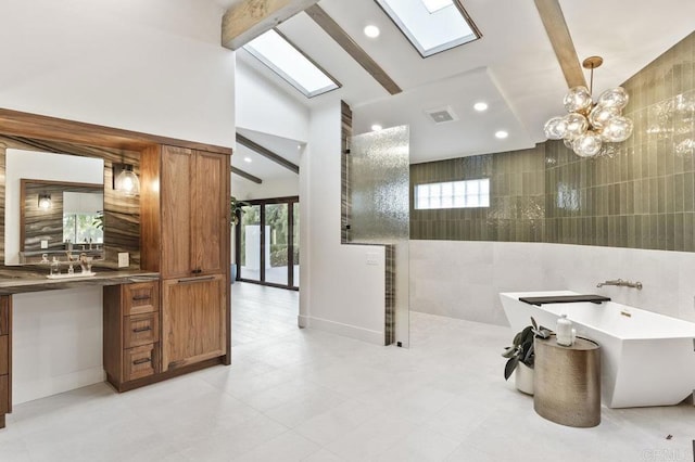 bathroom featuring lofted ceiling with skylight, tile walls, an inviting chandelier, vanity, and a walk in shower