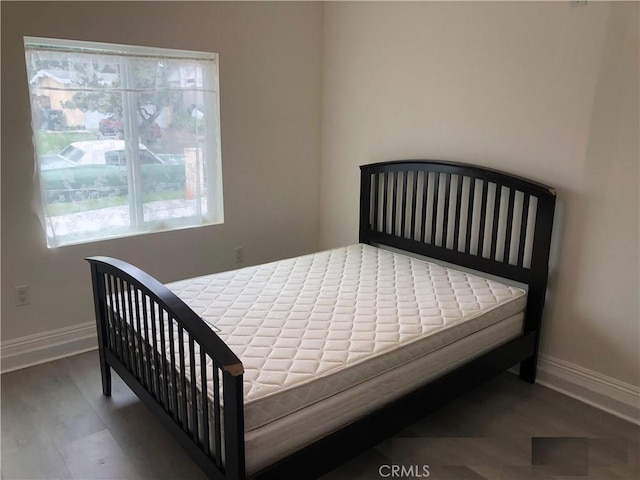 bedroom featuring baseboards and wood finished floors