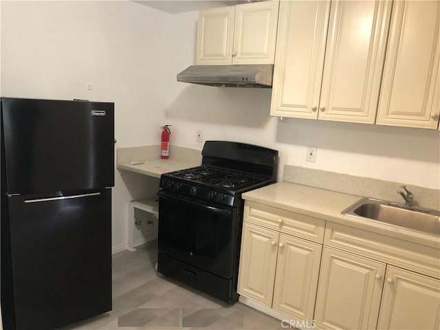 kitchen with a sink, under cabinet range hood, black appliances, and light countertops