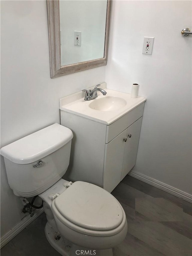 half bathroom with vanity and toilet