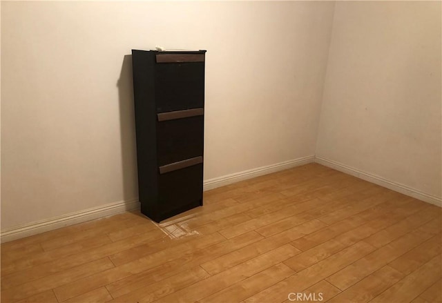 unfurnished room featuring baseboards and light wood-style floors