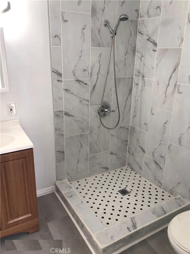 bathroom featuring vanity, toilet, and a stall shower