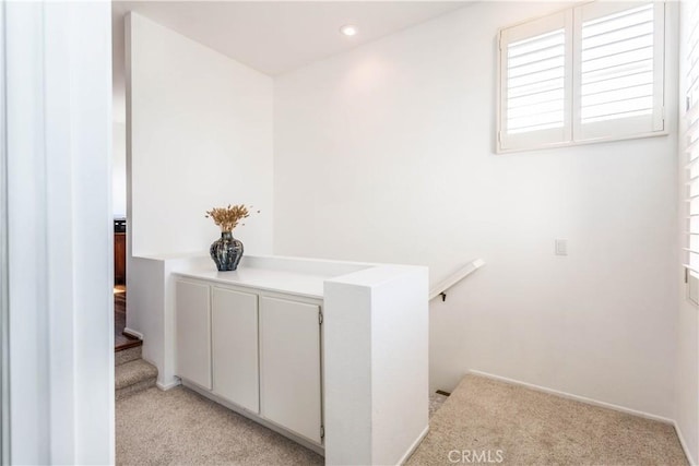 corridor with light colored carpet, baseboards, a wealth of natural light, and recessed lighting