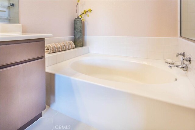full bathroom with a garden tub and vanity