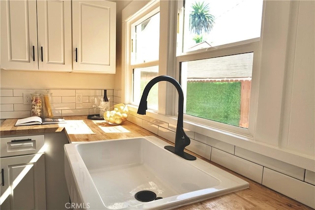 3222 E 10th St, Long Beach, CA 90804 - kitchen view of a sink, backsplash, wooden counters, and white cabinets