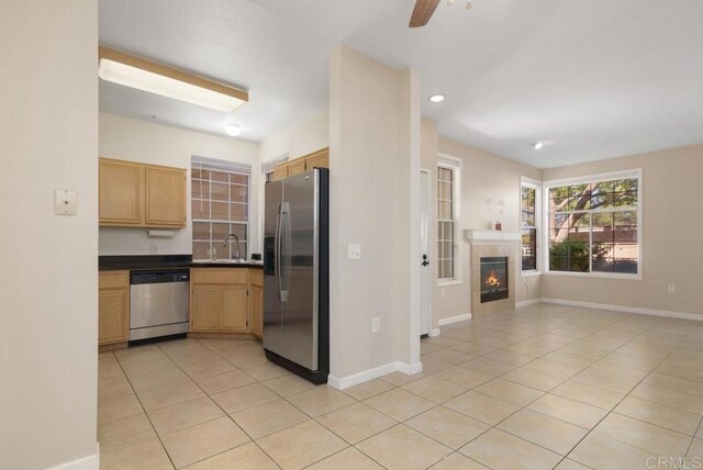 18614 Caminito Cantilena Unit 324, San Diego, CA 92128 - kitchen featuring stainless steel appliances, light tile patterned floors, dark countertops, open floor plan, and light brown cabinetry