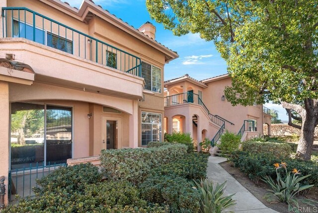 18614 Caminito Cantilena Unit 324, San Diego, CA 92128 - doorway to property featuring stucco siding and a chimney