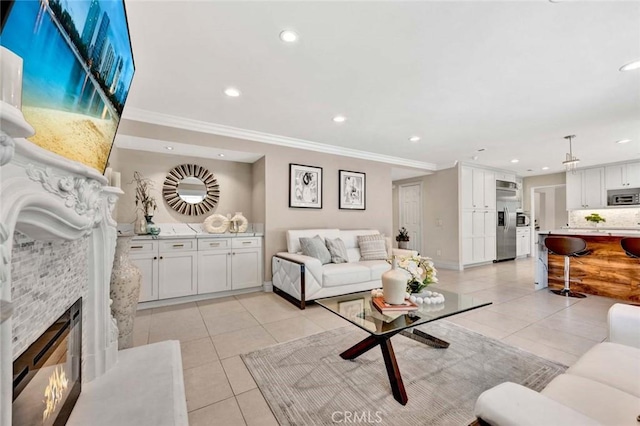 living area with light tile patterned floors, crown molding, recessed lighting, a fireplace, and baseboards