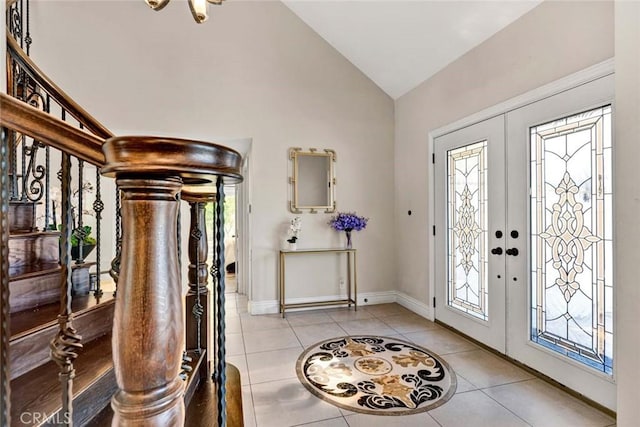 entryway with light tile patterned floors, healthy amount of natural light, high vaulted ceiling, baseboards, and stairway