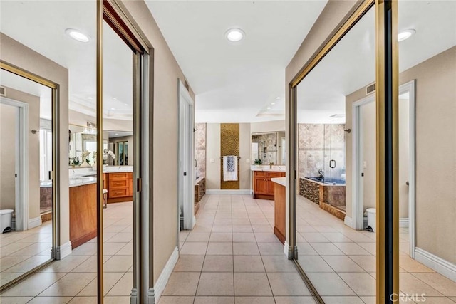 corridor with light tile patterned flooring and baseboards