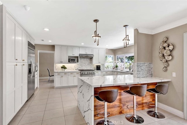 kitchen featuring stainless steel appliances, a peninsula, tasteful backsplash, light tile patterned floors, and baseboards