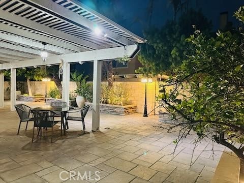 patio at twilight featuring fence, a pergola, and outdoor dining space