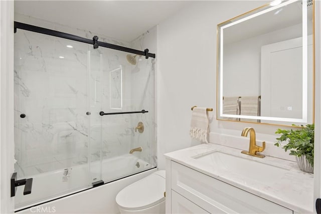bathroom featuring enclosed tub / shower combo, toilet, and vanity