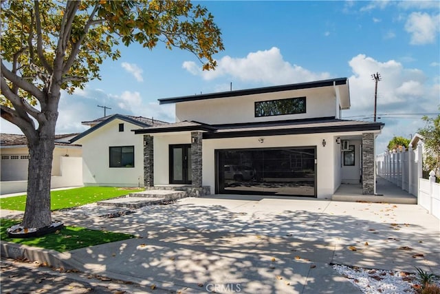 view of front facade featuring fence, stucco siding, driveway, stone siding, and a garage