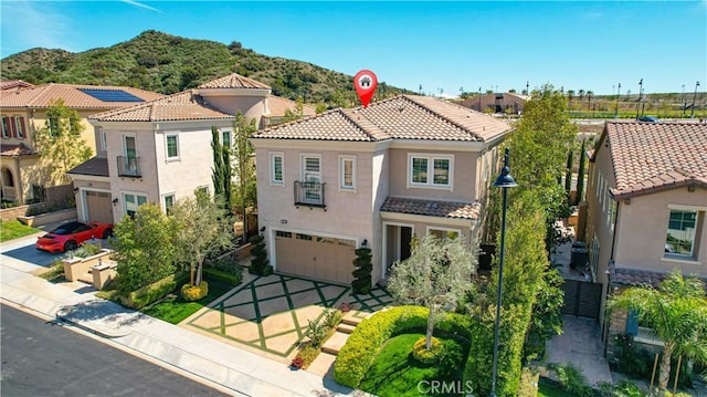 20512 W Esmeralda Ln, Porter Ranch, CA 91311 - mediterranean / spanish-style house featuring an attached garage, a tile roof, stucco siding, a mountain view, and driveway