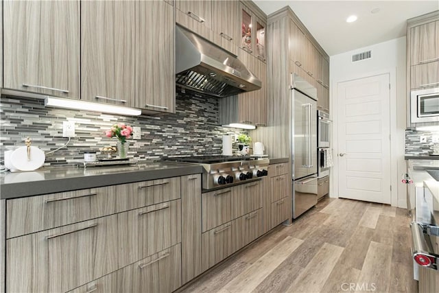 20512 W Esmeralda Ln, Porter Ranch, CA 91311 - kitchen featuring under cabinet range hood, dark countertops, appliances with stainless steel finishes, light wood finished floors, and recessed lighting
