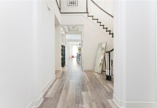 20512 W Esmeralda Ln, Porter Ranch, CA 91311 - hallway featuring wood finished floors, baseboards, stairs, and a towering ceiling