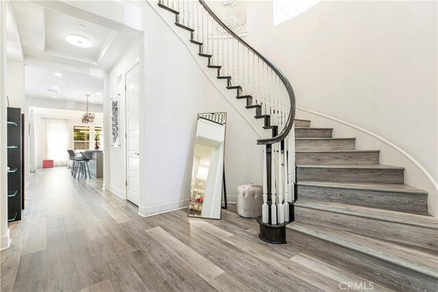 20512 W Esmeralda Ln, Porter Ranch, CA 91311 - stairway with wood finished floors, a tray ceiling, and baseboards
