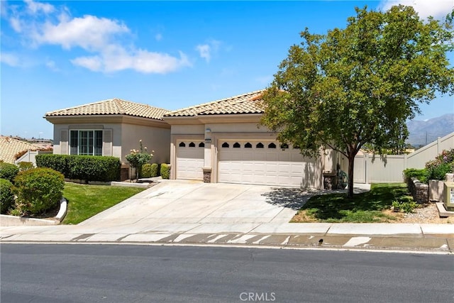 5536 Breckenridge Ave, Banning, CA 92220 - mediterranean / spanish-style house with a garage, a tiled roof, fence, stucco siding, and driveway