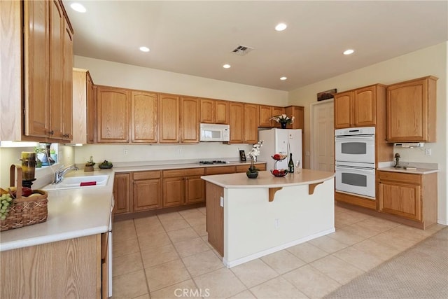 5536 Breckenridge Ave, Banning, CA 92220 - kitchen with white appliances, a sink, a kitchen island, light countertops, and recessed lighting