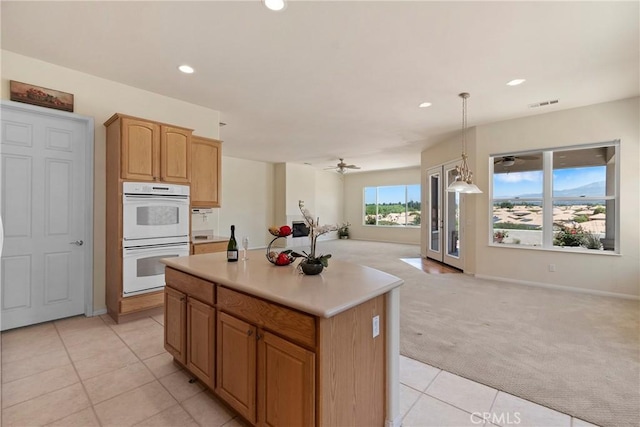 5536 Breckenridge Ave, Banning, CA 92220 - kitchen with white double oven, light carpet, open floor plan, recessed lighting, and light tile patterned flooring