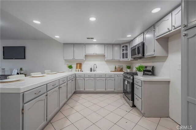 11249 Ferina St, Norwalk, CA 90650 - kitchen featuring appliances with stainless steel finishes, a peninsula, a sink, light tile patterned floors, and recessed lighting