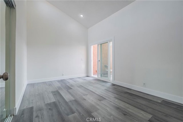 unfurnished room with high vaulted ceiling, baseboards, wood finished floors, and recessed lighting