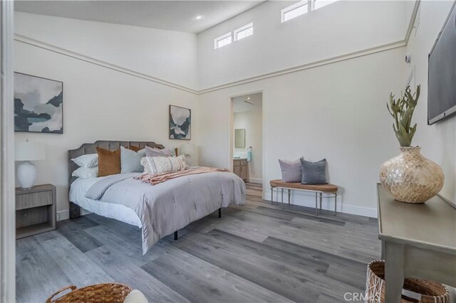 11249 Ferina St, Norwalk, CA 90650 - bedroom with wood finished floors, ensuite bath, a high ceiling, and baseboards