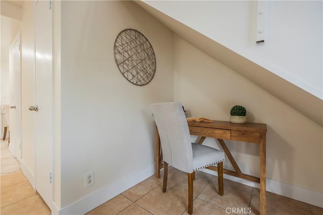 office featuring vaulted ceiling, baseboards, and light tile patterned floors