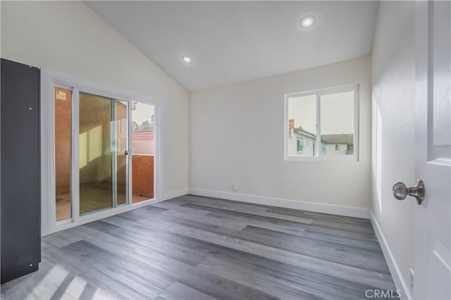 empty room with recessed lighting, vaulted ceiling, wood finished floors, and baseboards