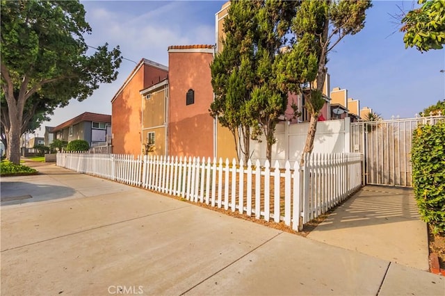 view of side of property with stucco siding and a fenced front yard