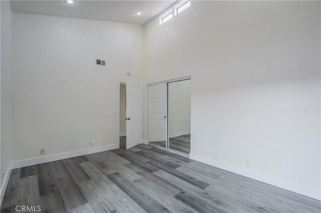 unfurnished room with recessed lighting, wood finished floors, and baseboards