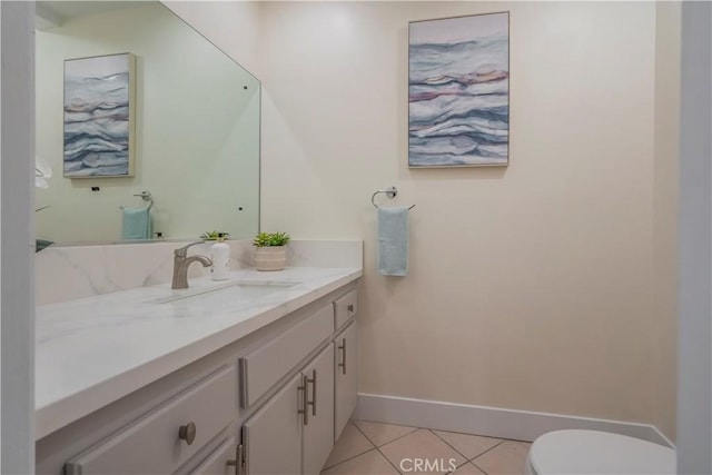 bathroom featuring tile patterned floors, baseboards, vanity, and toilet