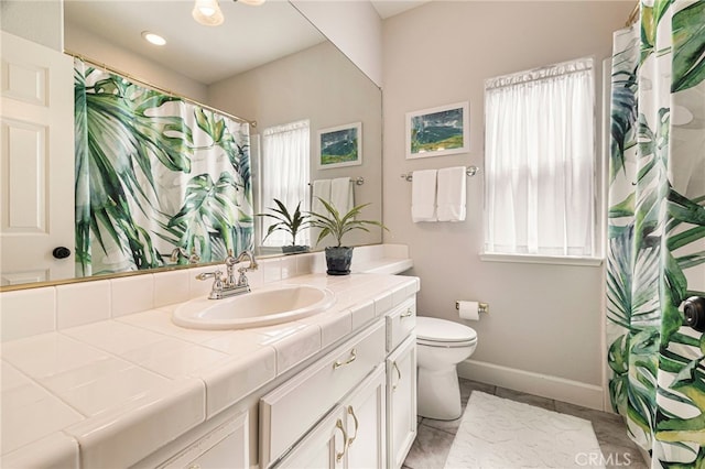 bathroom featuring baseboards, vanity, a shower with shower curtain, and toilet