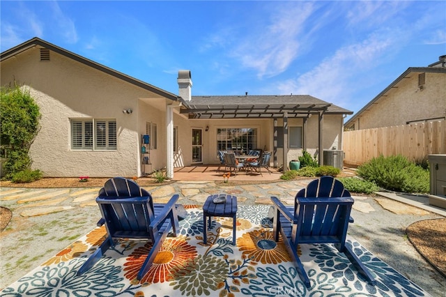back of house with a chimney, central AC unit, fence, stucco siding, and a patio area
