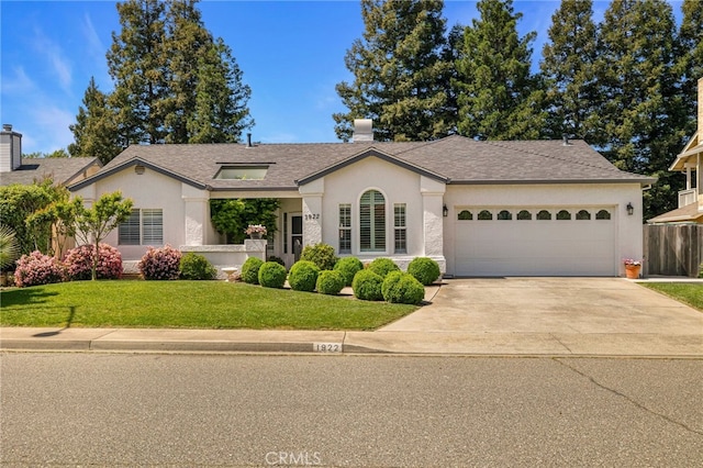 single story home with an attached garage, driveway, a front yard, and stucco siding