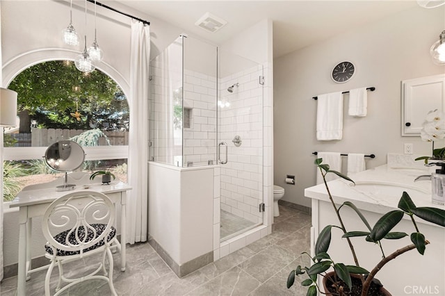 bathroom with baseboards, toilet, vanity, and a stall shower
