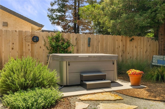 exterior space with fence and a hot tub