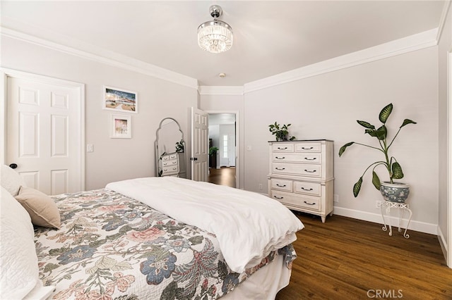 bedroom featuring baseboards, dark wood finished floors, and crown molding