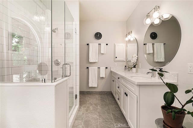 bathroom featuring baseboards, a sink, double vanity, and a stall shower