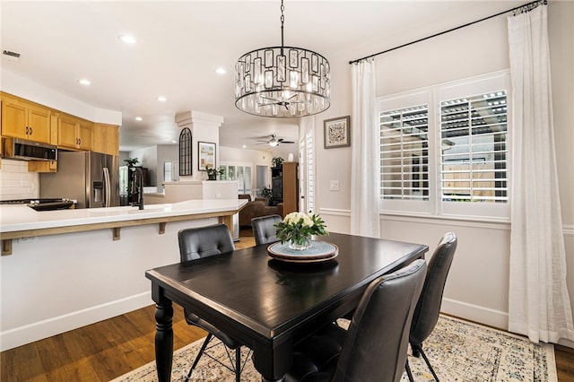 dining area featuring dark wood-style floors, a wealth of natural light, baseboards, recessed lighting, and ceiling fan with notable chandelier